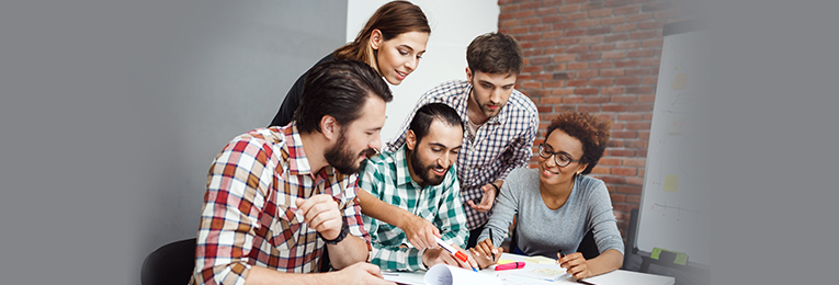 five people seen at a group discussion by glancing through few documents on the table